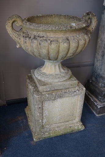 A pair of reconstituted stone campana garden urns on stands, diameter 60cm, height 82cm